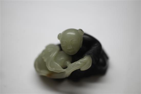 A Chinese pale celadon and dark grey jade and stand